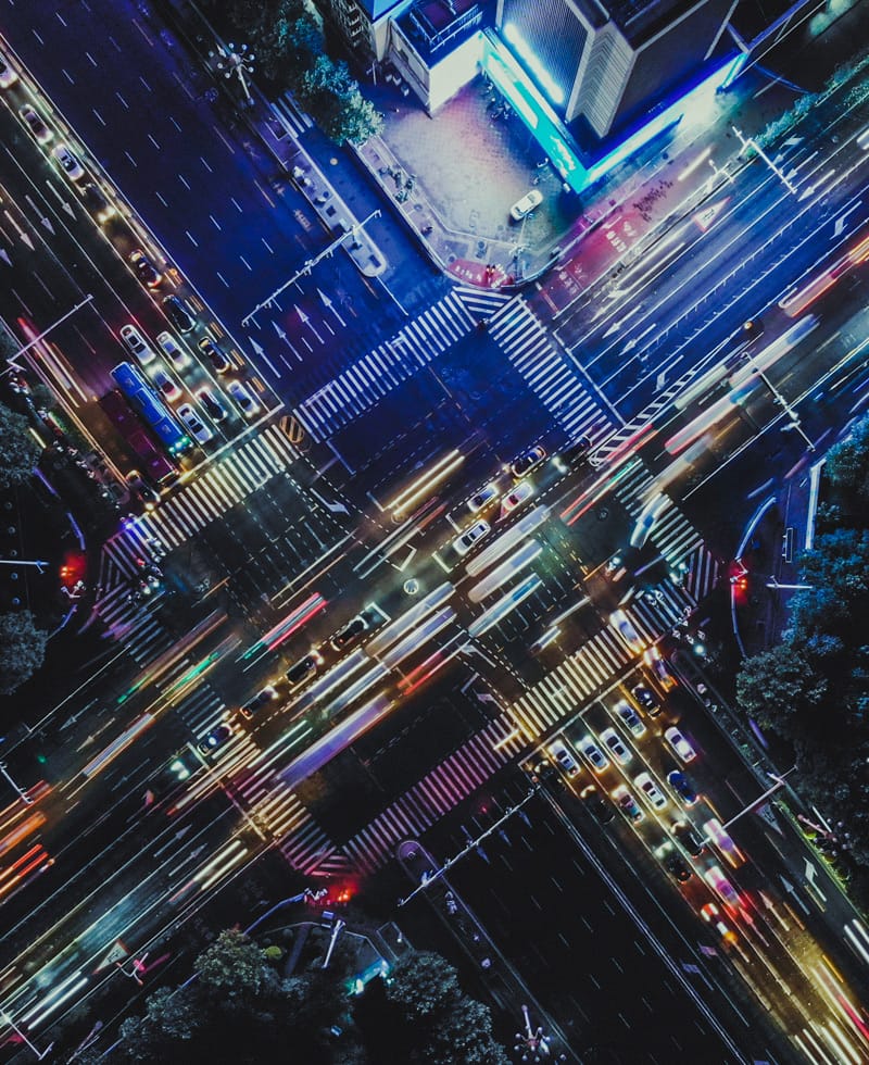 Aerial view of a busy city intersection with traffic lights and cars.